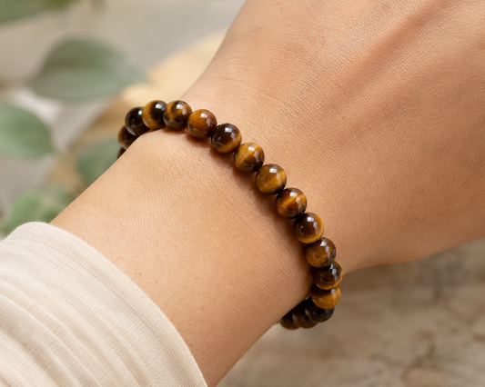 Bracelet en Œil de Tigre porté au poignet, perles en pierre naturelle aux reflets dorés dans un style naturel et élégant.