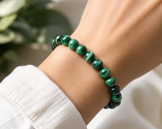 Bracelet en Œil de Tigre traité vert porté au poignet, avec perles vertes aux reflets chatoyants.