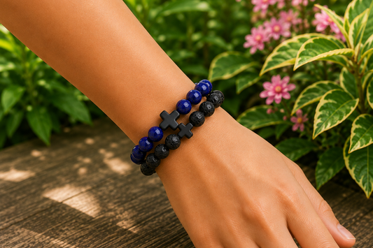 Bracelets Pierre de Lave et Sodalite bleue portés au poignet, avec perles noires texturées et perles bleues devant un décor végétal.