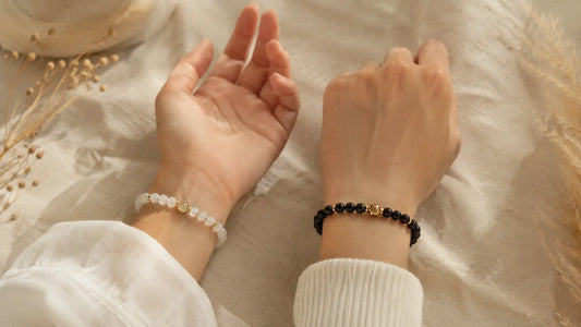 Bracelets en pierres naturelles portés aux deux poignets pour illustrer le choix entre poignet gauche et poignet droit en lithothérapie.