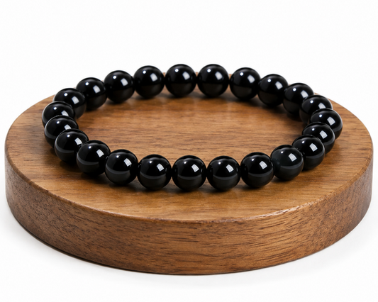Bracelet en Agate naturelle traitée noire présenté sur un socle en bois, avec perles noires brillantes sur fond blanc.