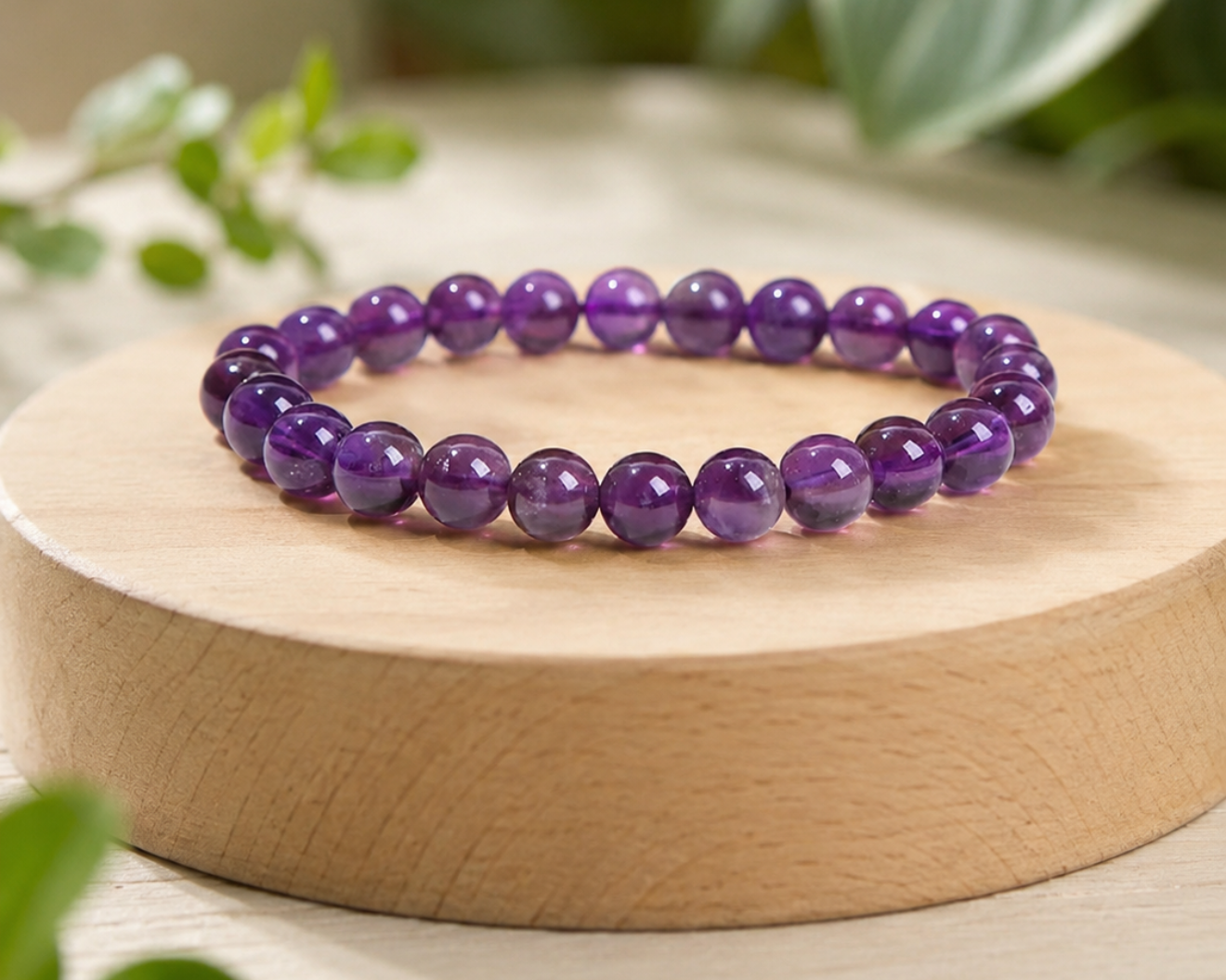 Bracelet en Améthyste présenté sur un socle en bois, avec perles violettes en pierre naturelle dans un décor végétal doux.