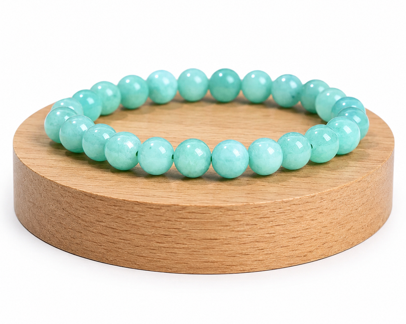 Bracelet en Aventurine verte présenté sur un socle en bois fond blanc, avec perles vert clair en pierre naturelle.