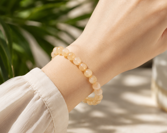 Bracelet en Citrine chauffée issue d’Améthyste naturelle porté au poignet, avec perles jaune doré.
