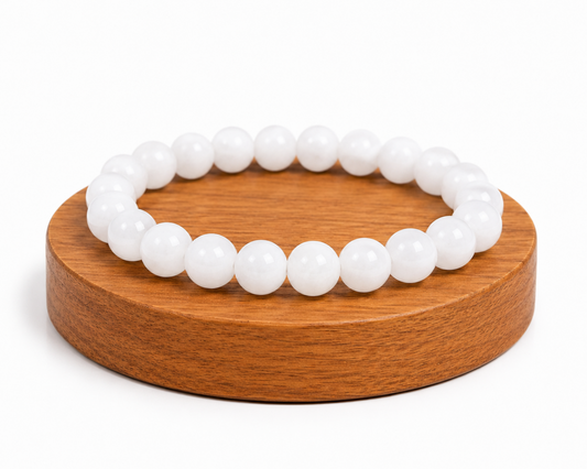 Bracelet en Jade Blanc naturel présenté sur un socle en bois fond blanc, avec perles blanches lumineuses.