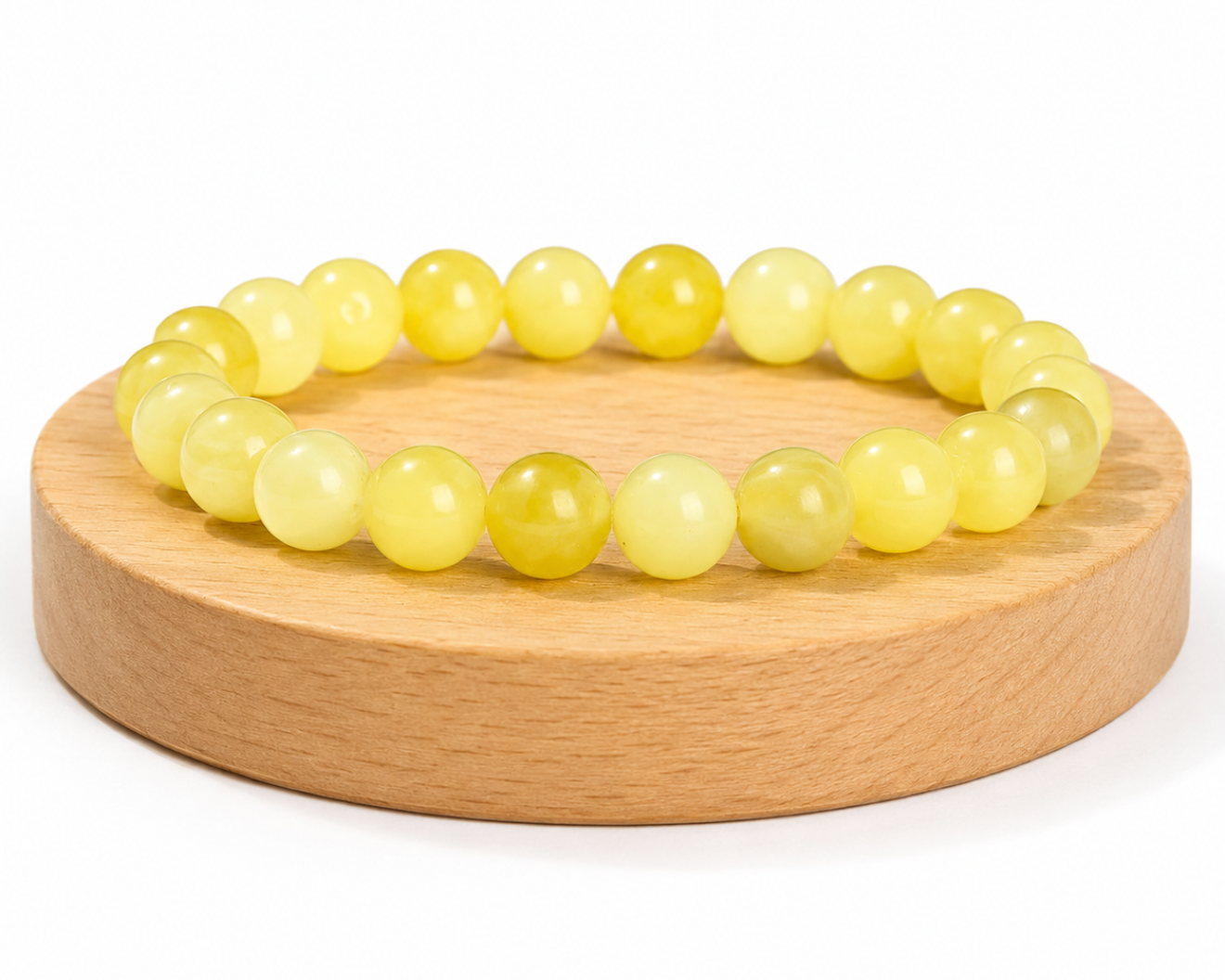 Bracelet en Serpentinite naturelle teintée jaune, appelée Jade Citron, présenté sur un socle en bois fond blanc.