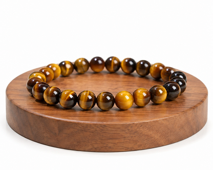 Bracelet en Œil de Tigre naturel présenté sur un socle en bois fond blanc, avec perles aux reflets dorés et bruns.