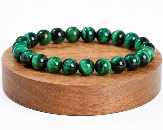 Bracelet en Œil de Tigre traité vert présenté sur un socle en bois, avec perles chatoyantes sur fond blanc.