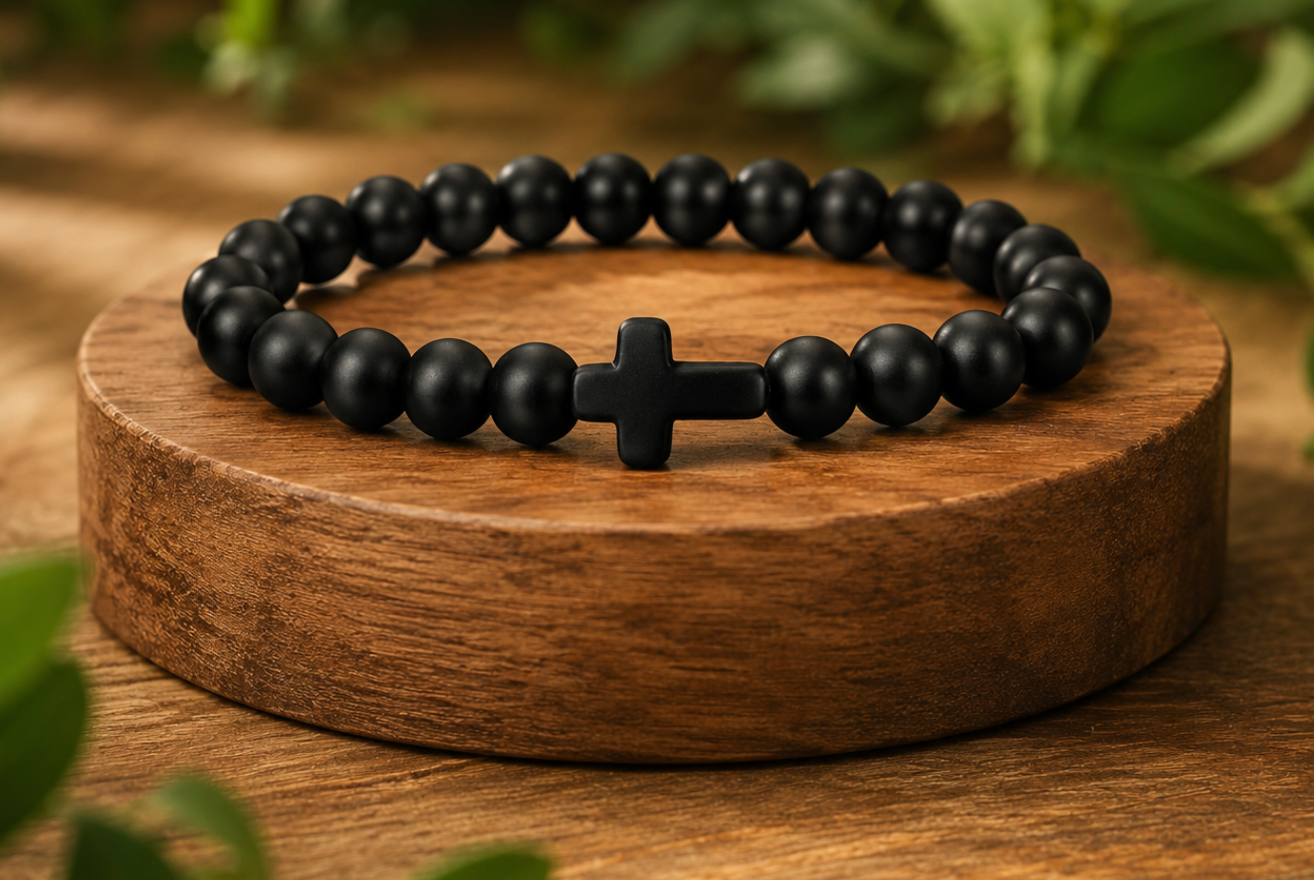 Bracelet en Onyx noir mat présenté sur un socle en bois, avec perles noires mates dans un décor végétal.
