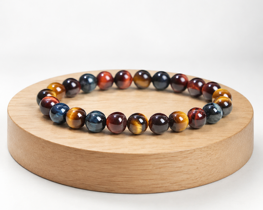 Bracelet triple protection présenté sur un socle en bois fond blanc, avec perles en Œil de Tigre, Œil de Taureau et Œil de Faucon.