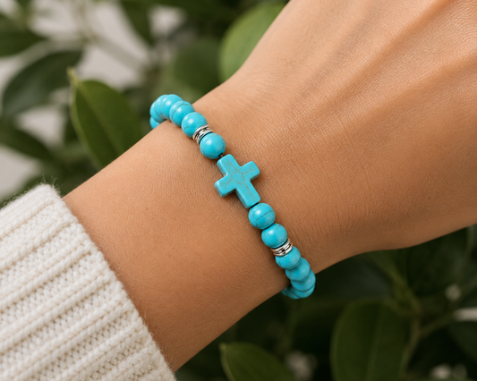 Bracelet en Turquenite, Howlite naturelle teintée azur, porté au poignet avec croix assortie.