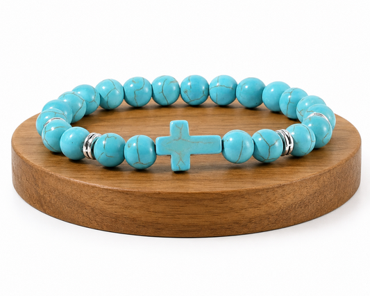 Bracelet en Turquenite, Howlite naturelle teintée azur, avec croix assortie sur un socle en bois fond blanc.