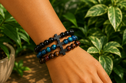 Bracelets Onyx noir, Œil de Faucon et triple protection portés au poignet, avec perles noires, bleues et brun doré.